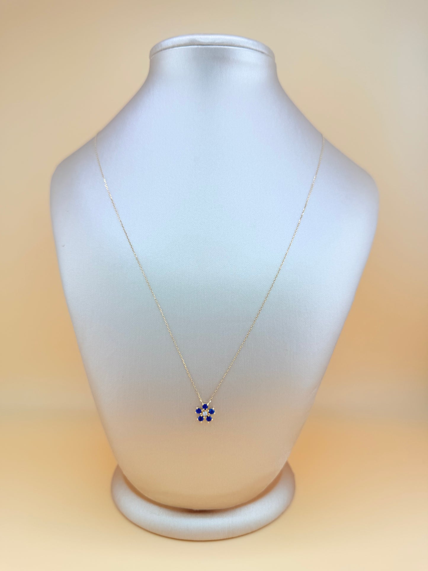 14kt gold necklace with a flower pendant, featuring a sapphire and natural diamond. 0.03 ct of natural diamonds and 0.36 ct of sapphire. Size 16”-18”