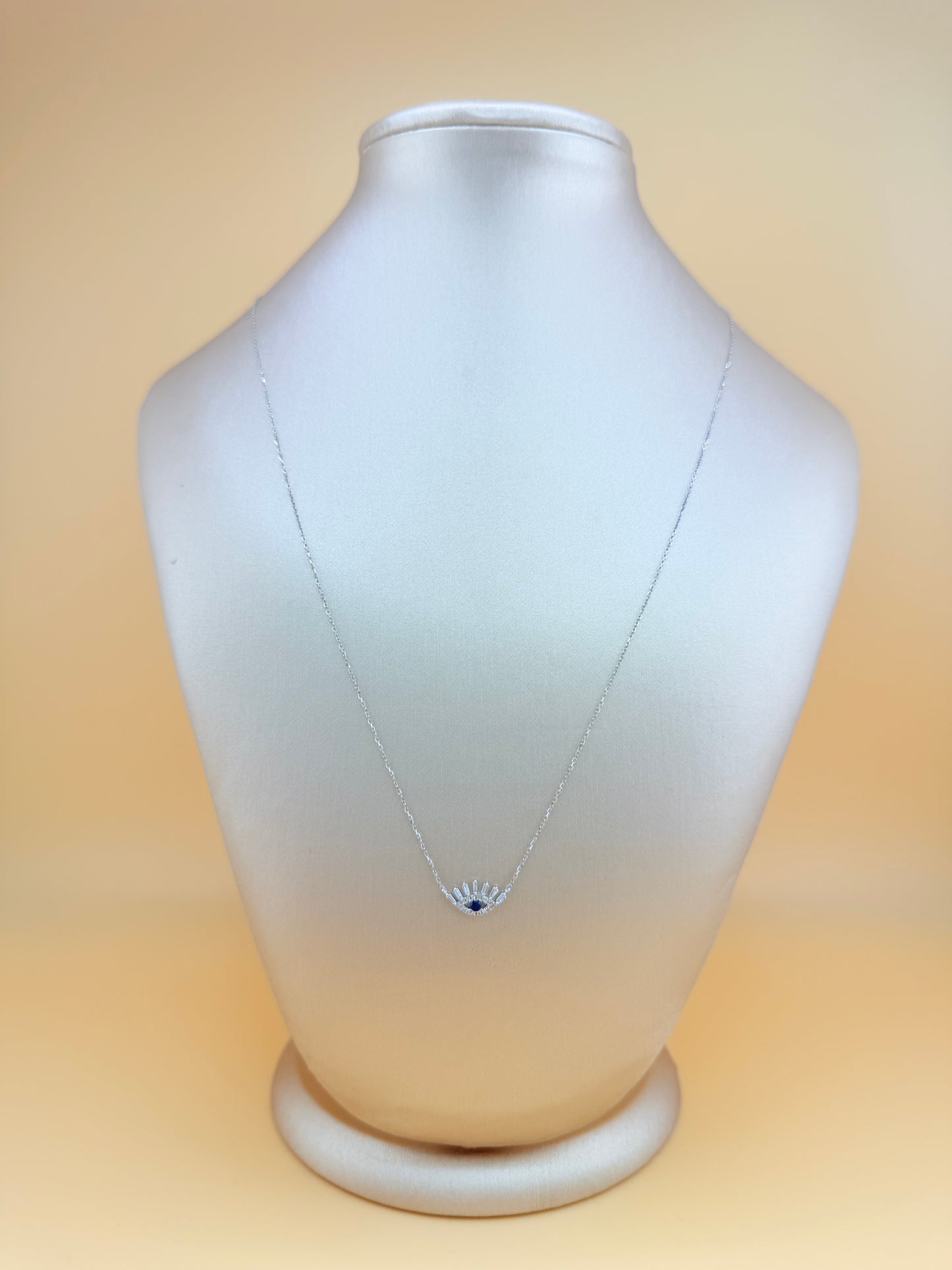 14kt gold necklace with a Turkish Evil Eye pendant, featuring natural diamonds and sapphire. 0.16 ct of natural diamonds and 0.07 ct of sapphire. Adjustable length: 16”–18”.
