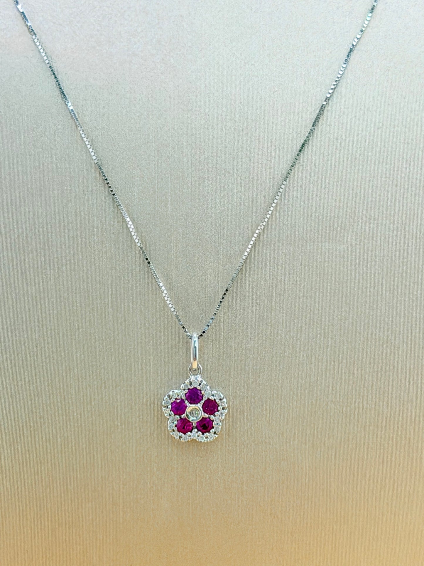 14kt white gold necklace with a flower pendant, featuring natural diamonds and ruby. Size 16”.