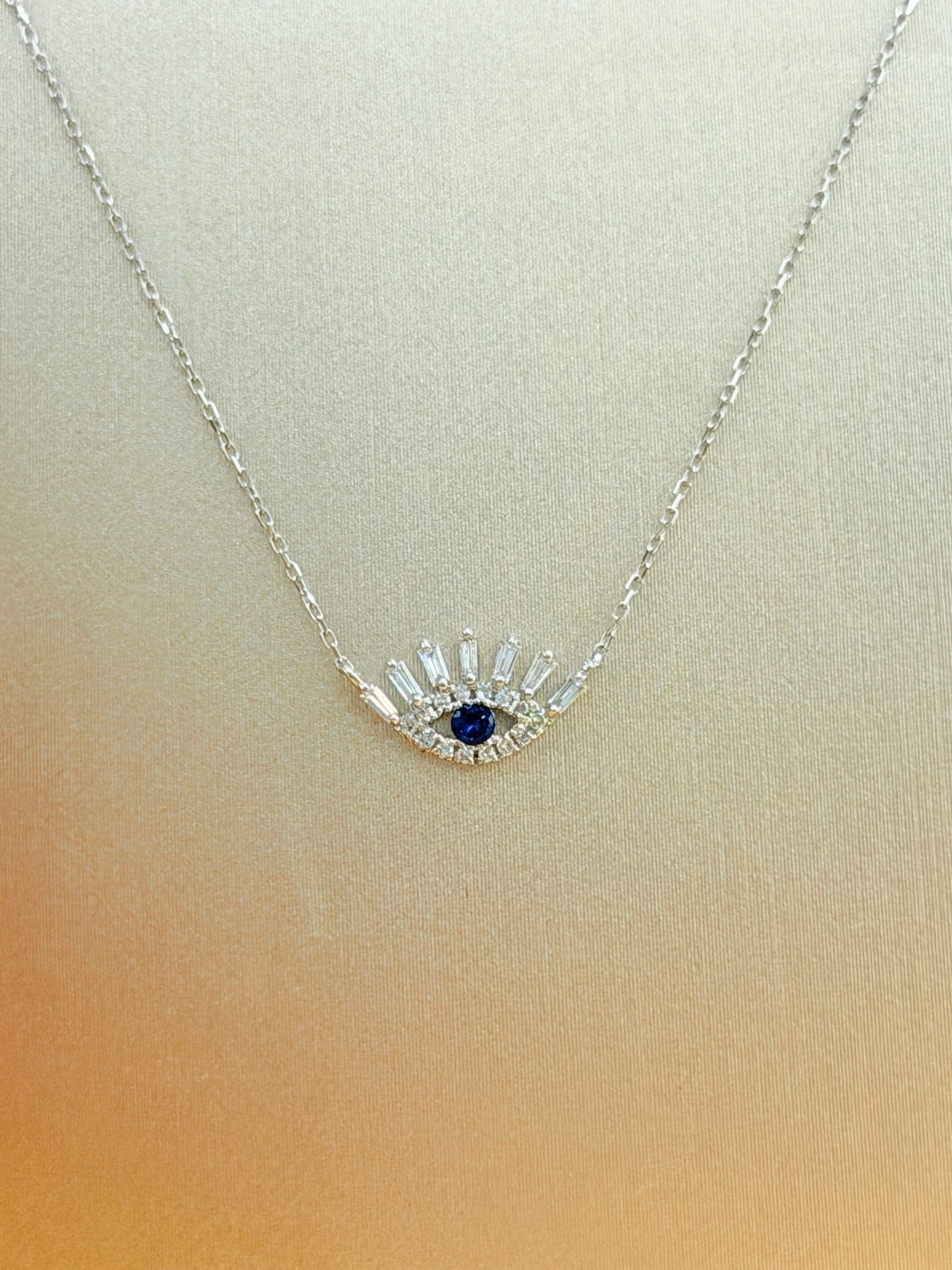 14kt gold necklace with a Turkish Evil Eye pendant, featuring natural diamonds and sapphire. 0.16 ct of natural diamonds and 0.07 ct of sapphire. Adjustable length: 16”–18”.