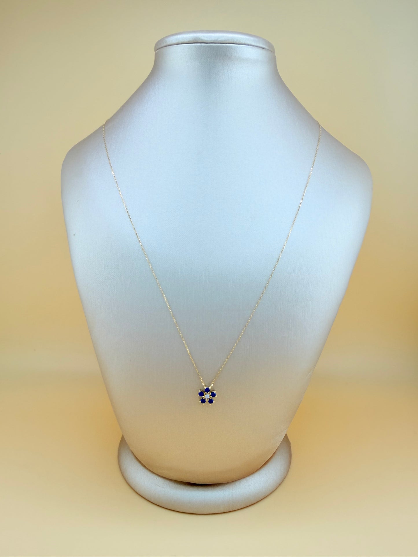 14kt gold necklace with a flower pendant, featuring a sapphire and natural diamond. 0.03 ct of natural diamonds and 0.36 ct of sapphire. Size 16”-18”